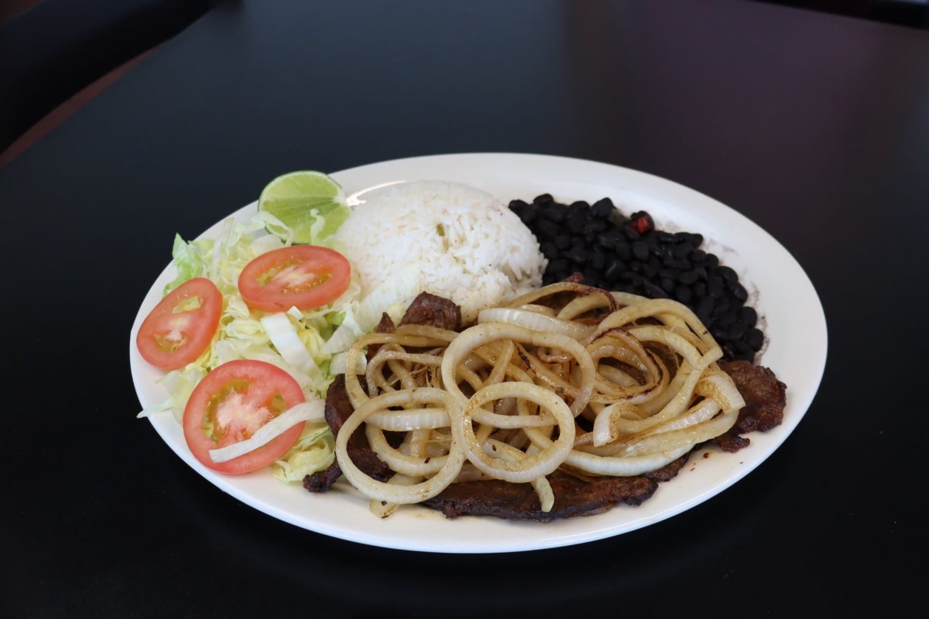 La Estrella entrée with meat, onions, rice, beans and salad