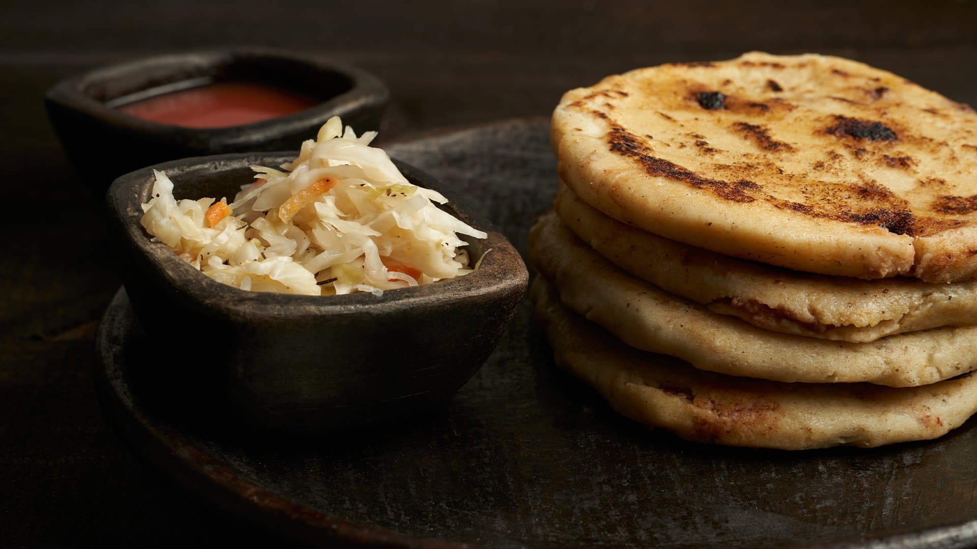 Pupusas with curtido and salsa, photographed for La Estrella